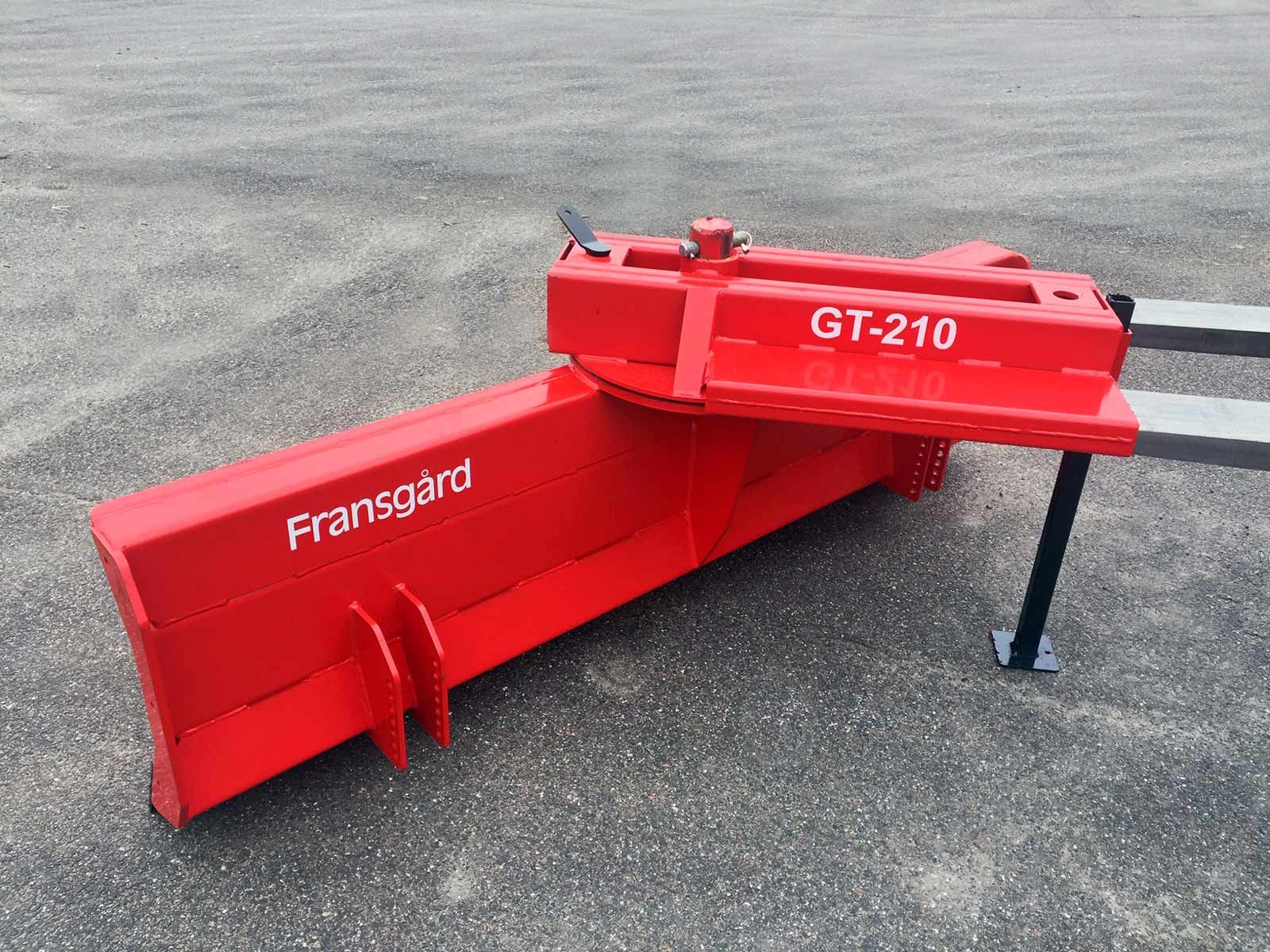 Ein roter Traktorpflug liegt auf dem Boden.