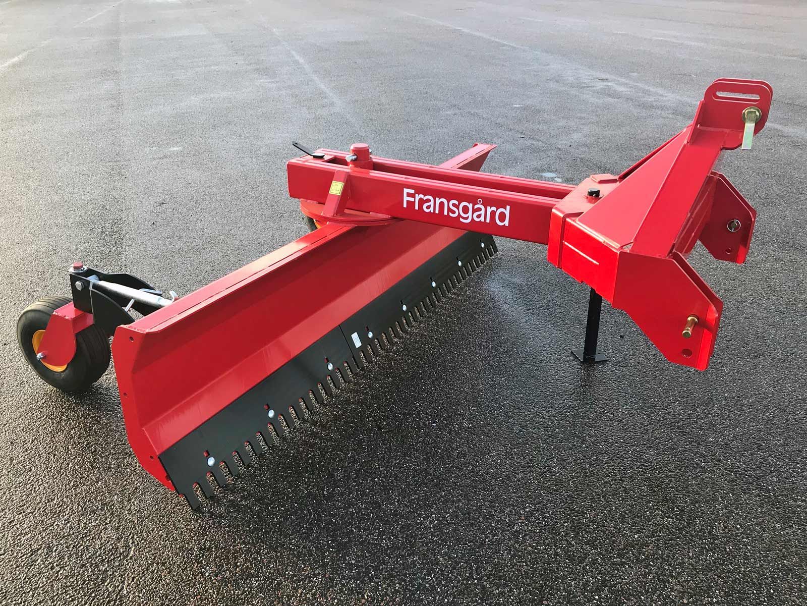 Ein roter Traktor steht am Straßenrand.