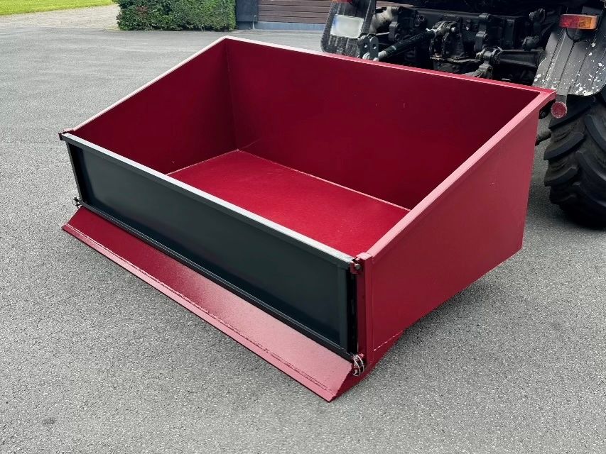 Ein roter Container ist an der Rückseite eines Traktors befestigt