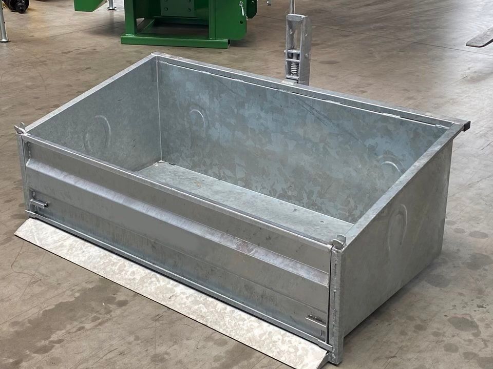 Auf einem Betonboden steht ein großer Metallbehälter.