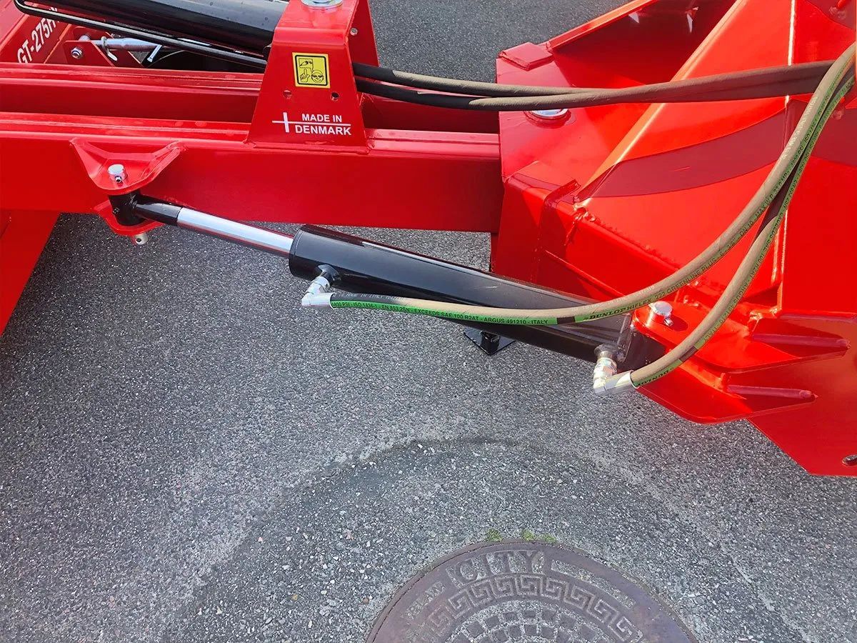 Ein roter Traktor steht am Straßenrand.