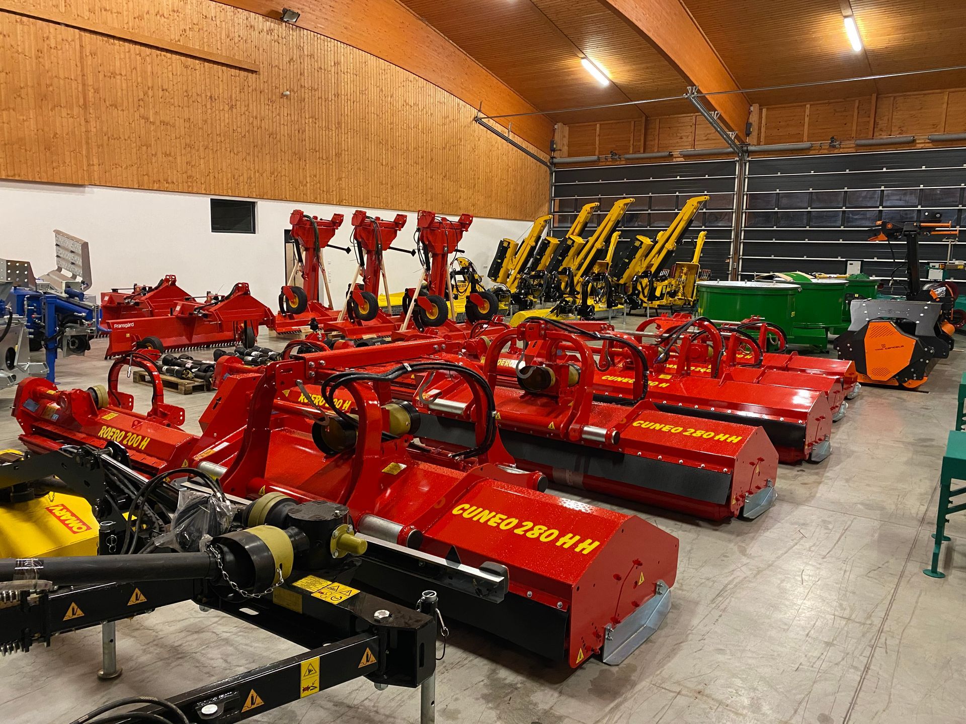 Ein großes Lagerhaus voller Traktoren und Maschinen.