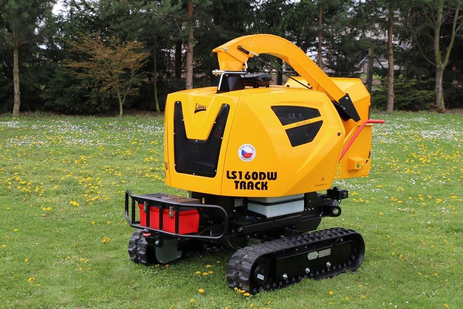 Ein gelber Traktor steht auf einer Wiese.