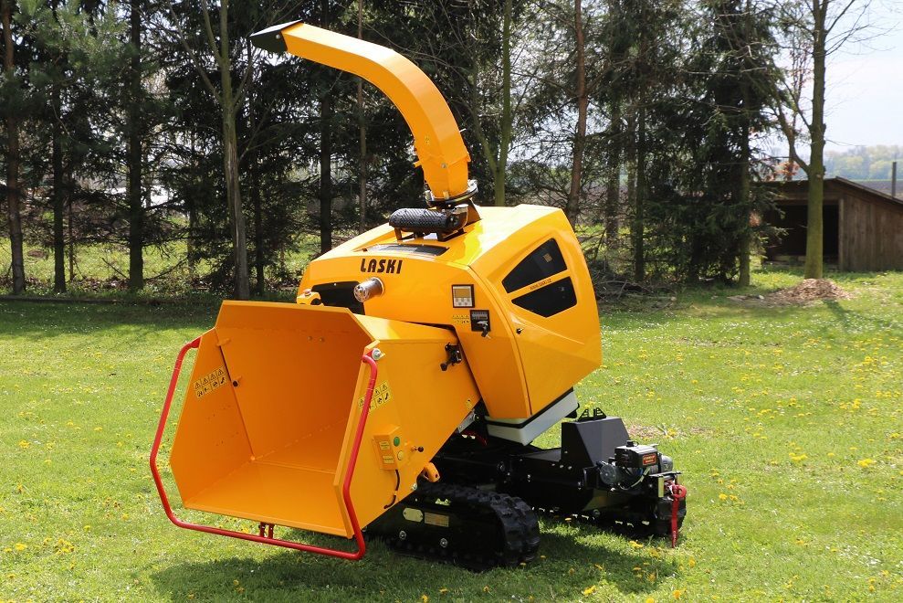 Eine gelbe Maschine steht auf einem üppigen grünen Feld.