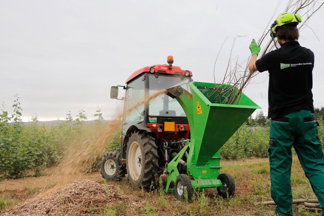 Ein Mann steht neben einem Traktor auf einem Feld.