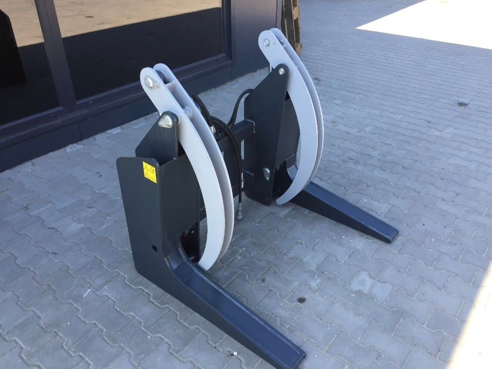 Auf einem gepflasterten Gehweg stehen zwei Greifarme eines Gabelstaplers.