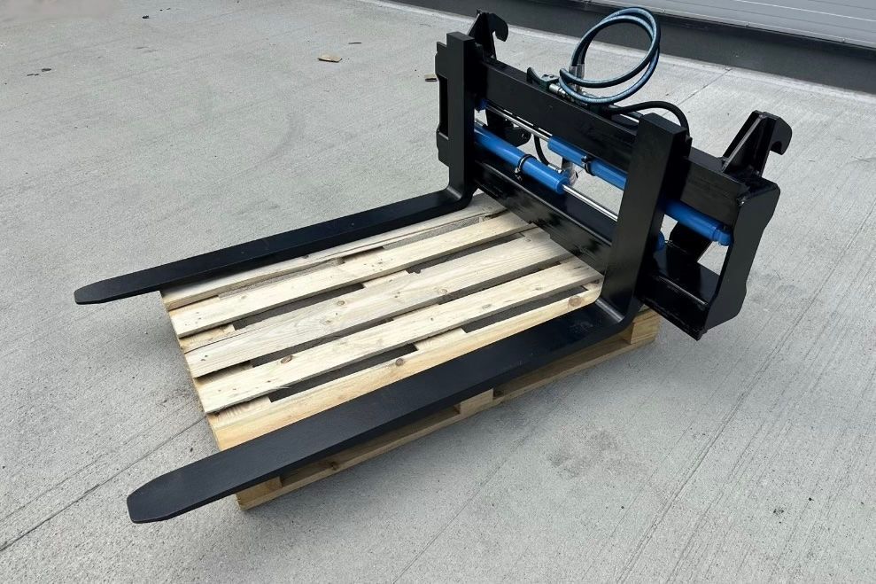 Schwarzer Palettengabelaufsatz auf einer Holzpalette im Freien.