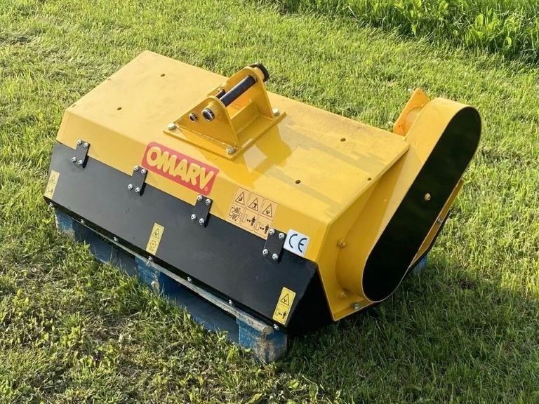 Ein gelb-schwarzer Omary-Rasenmäher steht auf einer Palette im Gras.