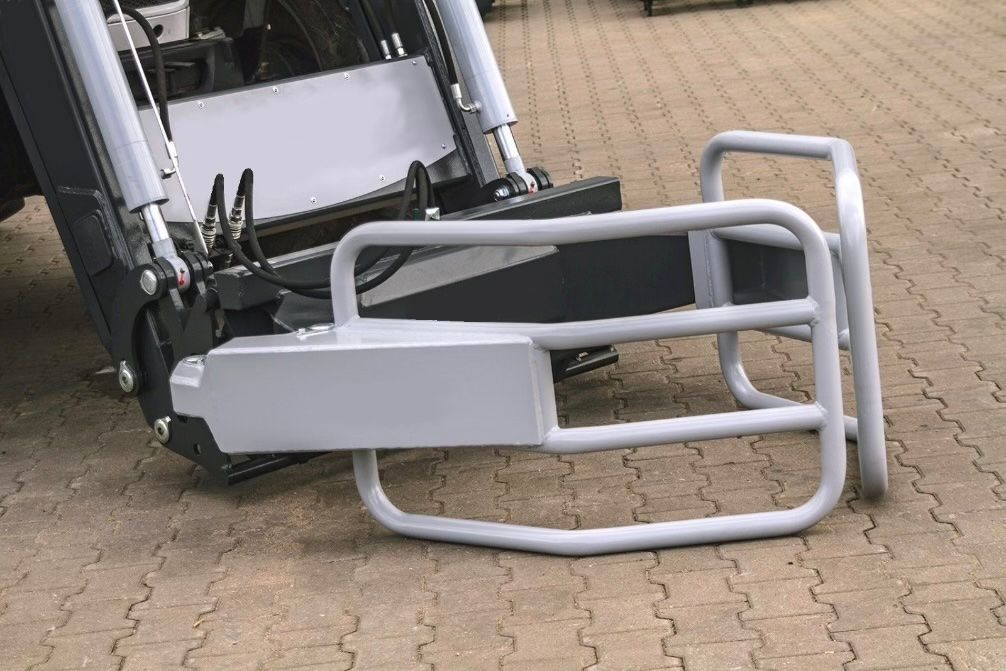 Eine Bullenballastklemme liegt neben einem Traktor auf dem Boden.