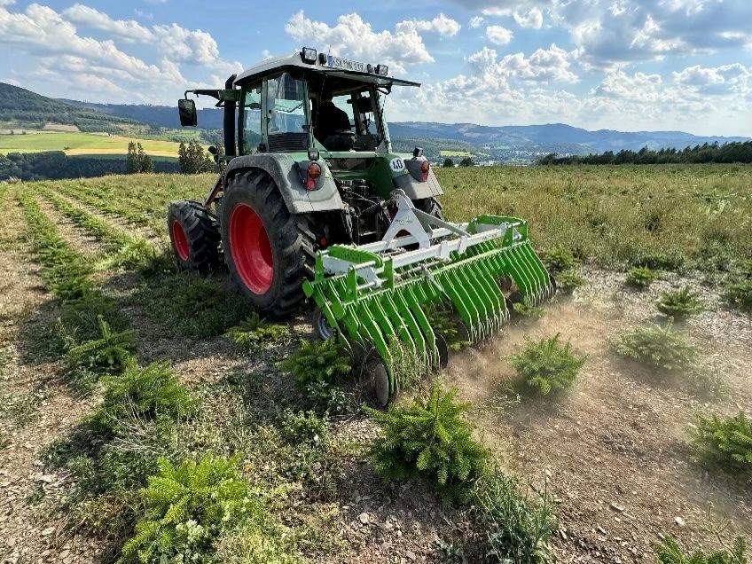 Ein Traktor schneidet Gras auf einem Feld.