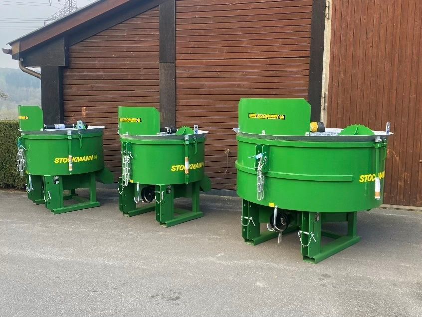 Drei grüne Mischer stehen vor einem Gebäude