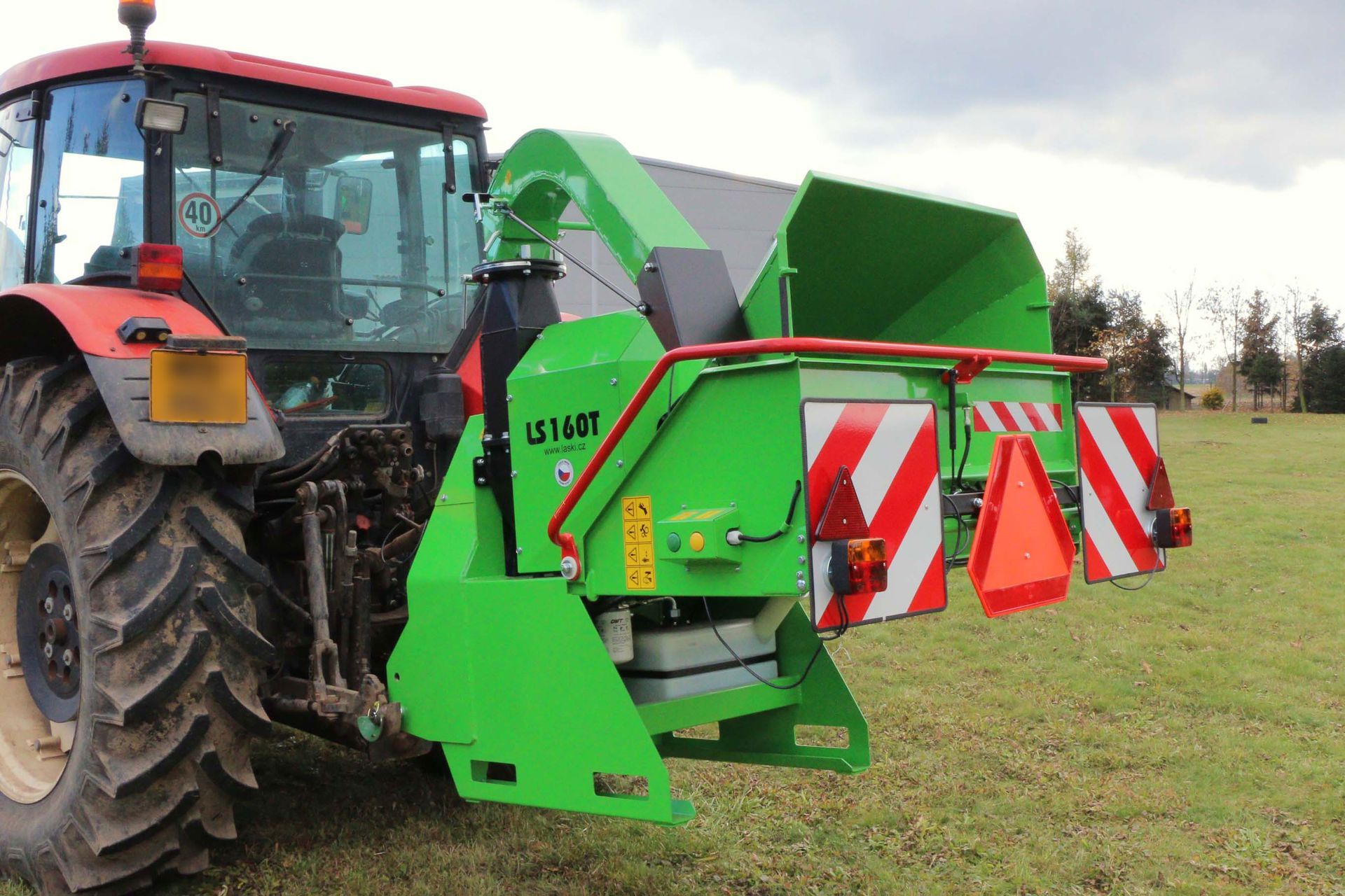 Ein grüner Traktor ist auf einer Wiese geparkt.