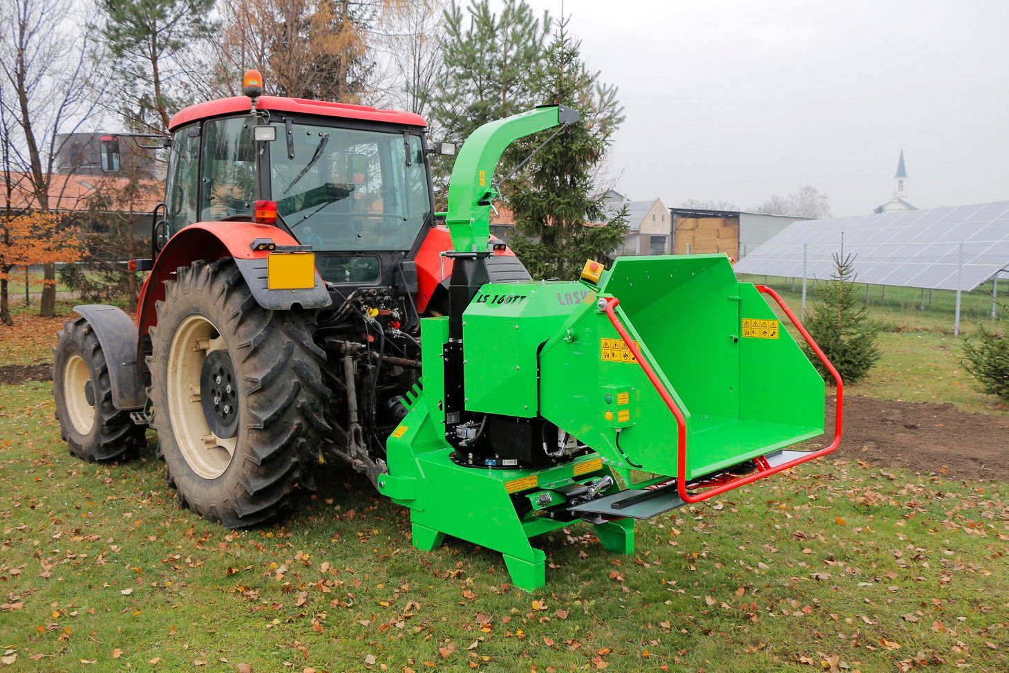 Ein grüner Traktor ist auf einer Wiese geparkt.