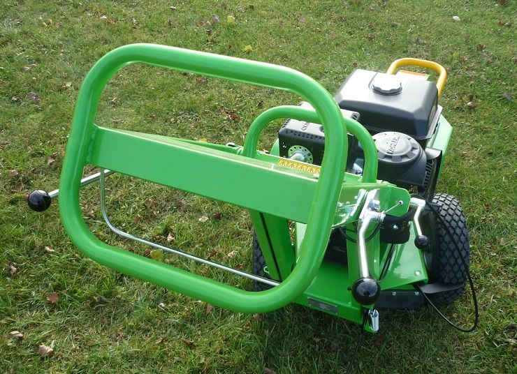 Ein grüner Rasenmäher steht im Gras