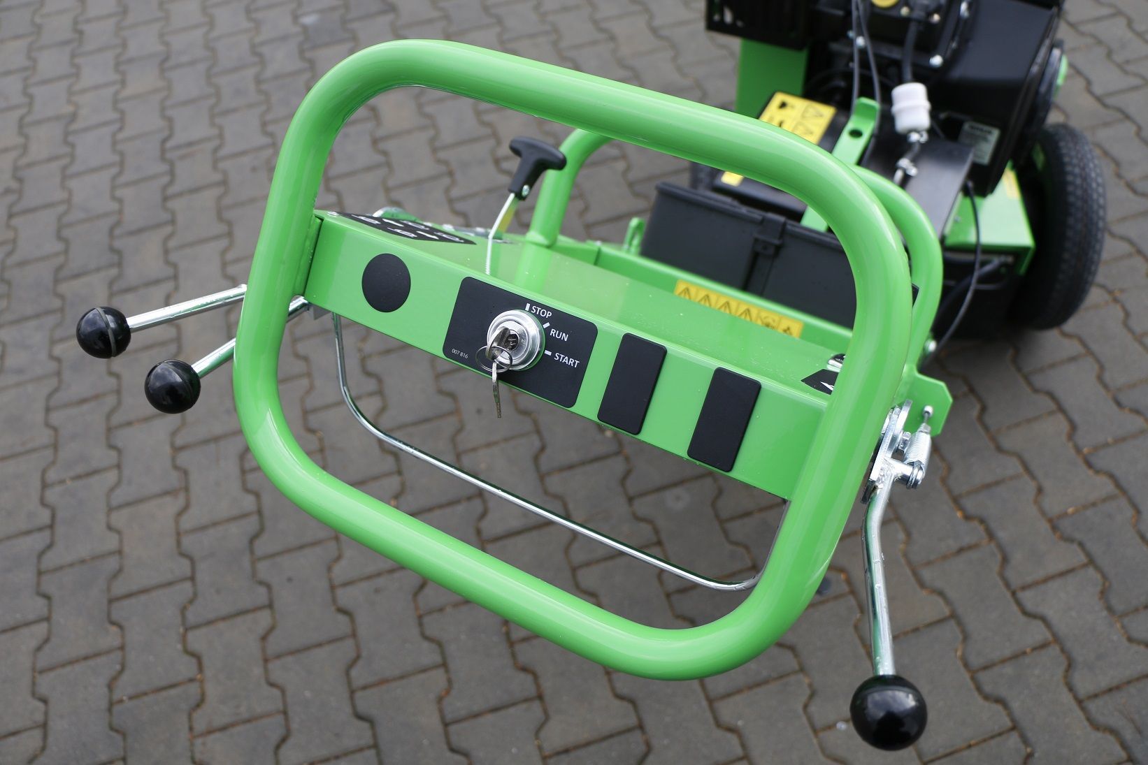 Ein grüner Traktor steht auf einem Ziegelsteinpflaster