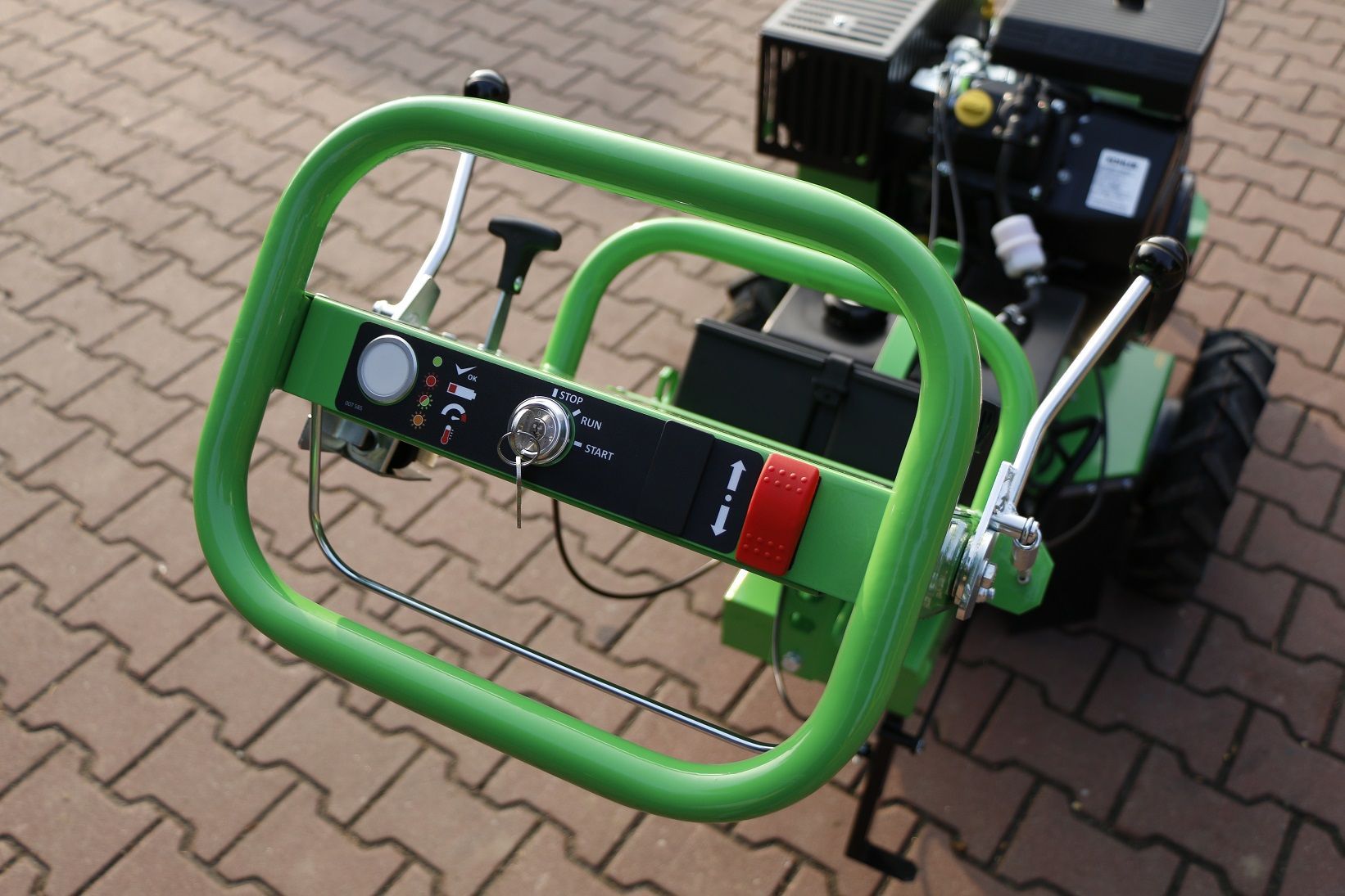 Ein grüner Traktor steht auf einer gepflasterten Auffahrt