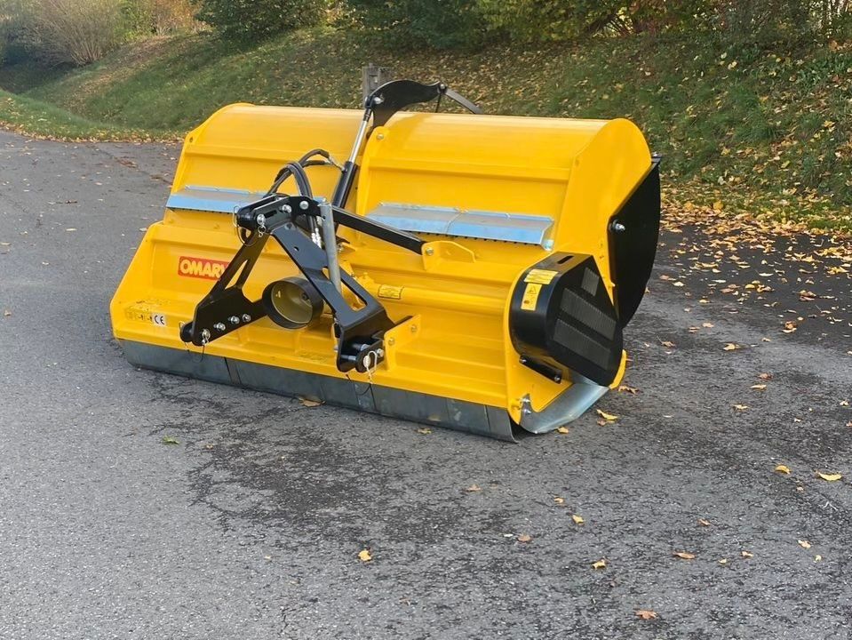 Ein gelber Traktor steht am Straßenrand.