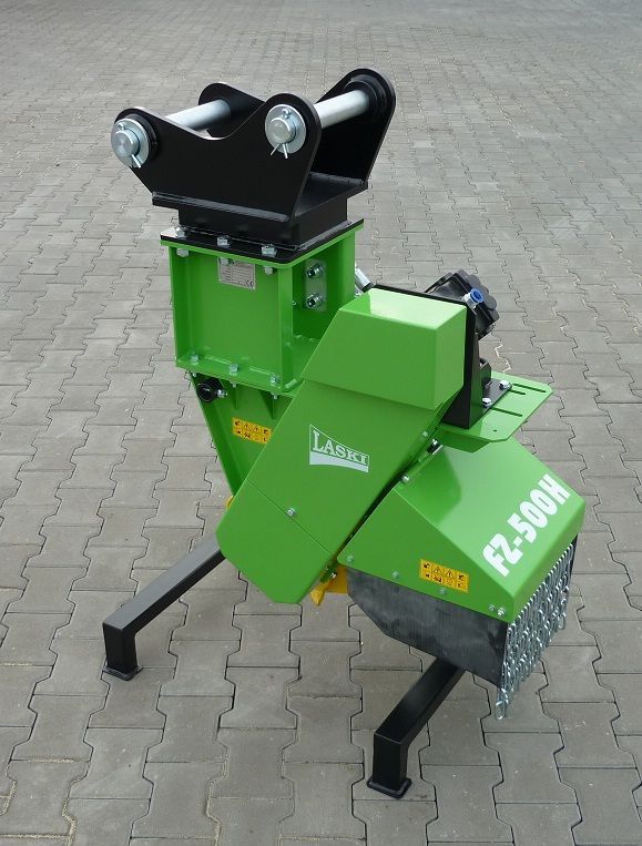 Eine grüne Maschine steht auf einem Ziegelsteinpflaster.