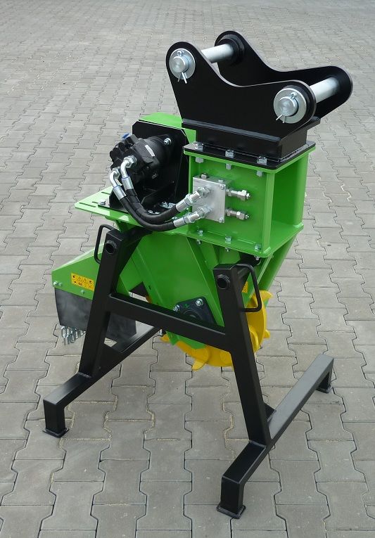 Eine grüne Maschine steht auf einem schwarzen Ständer auf einem gepflasterten Gehweg.