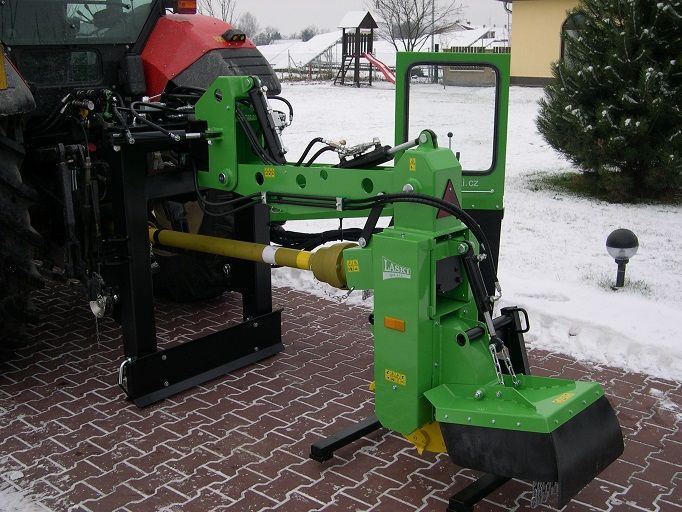 Eine grüne Maschine ist an einem roten Traktor befestigt