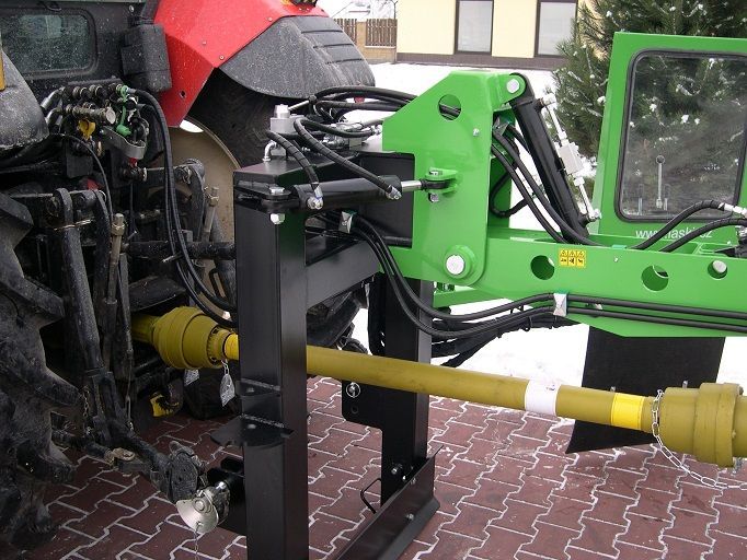 Ein grün-schwarzer Traktor steht auf einer gepflasterten Auffahrt