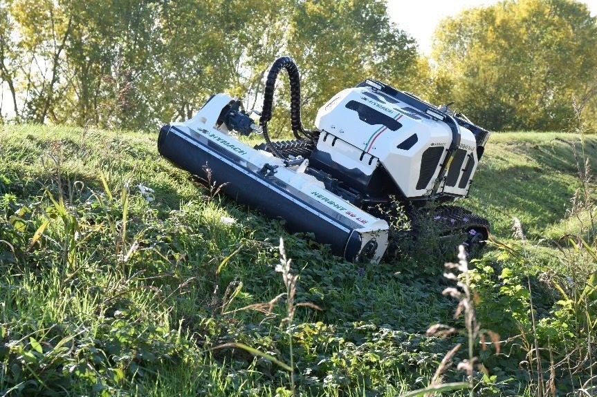 Ein weiß-schwarzes Fahrzeug steht auf einem grasbewachsenen Hügel.