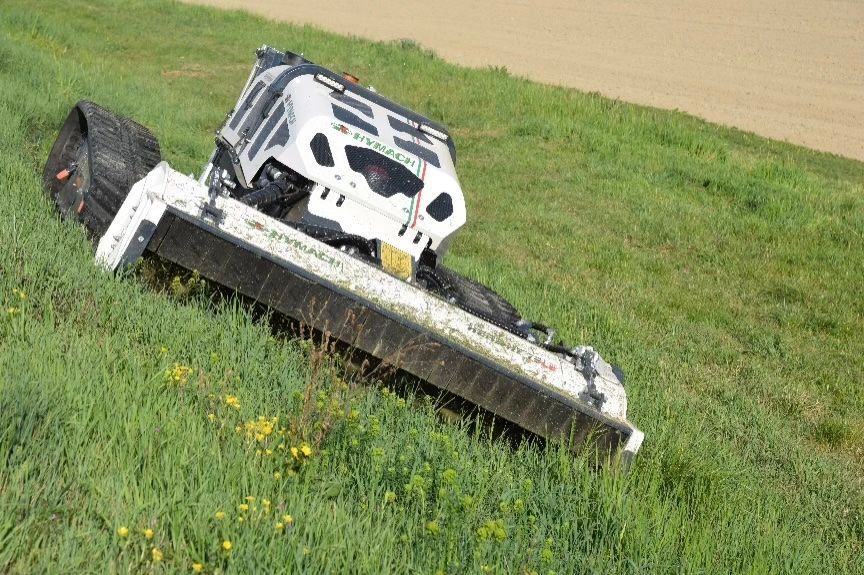 Ein Rasenmäher steht auf einem grasbewachsenen Hügel.