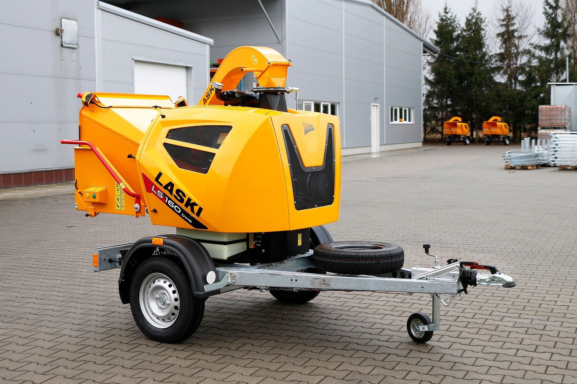 Eine gelbe Laski-Maschine steht auf einem Anhänger auf einem Parkplatz