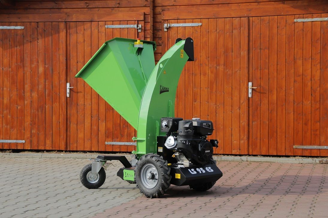 Eine grüne Maschine steht vor einem hölzernen Garagentor.