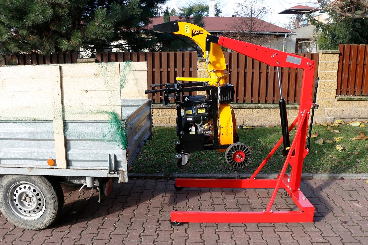 Ein rot-gelber Kran ist an einem Anhänger befestigt