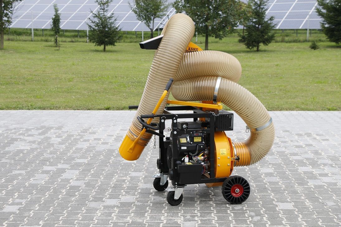 Auf einem gepflasterten Gehweg steht ein gelber Staubsauger.