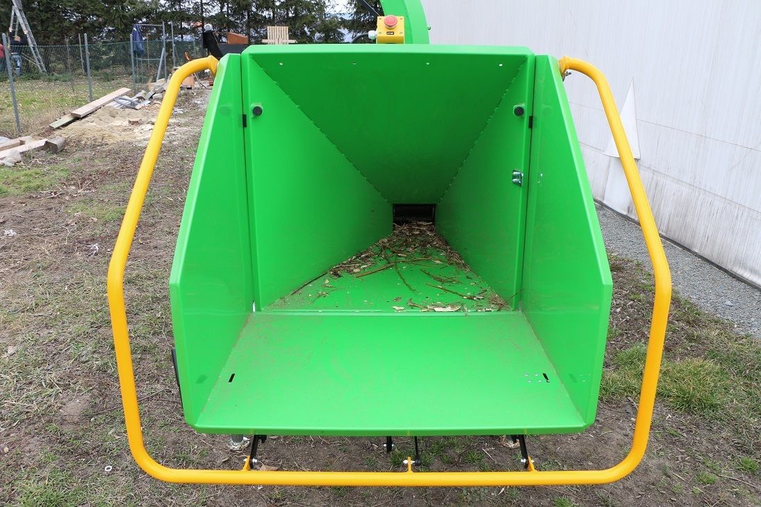 Eine grün-gelbe Maschine steht vor einem Gebäude auf dem Boden.