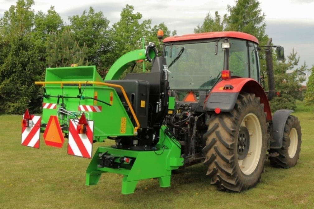 Ein grün-roter Traktor steht auf einer Wiese