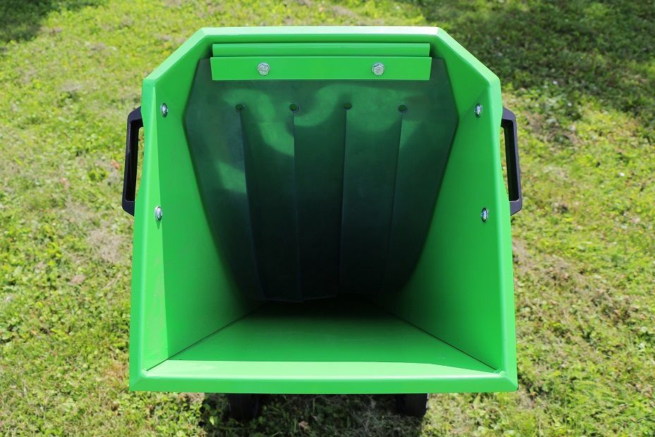 Eine grüne Mülltonne steht auf einem üppigen grünen Feld.