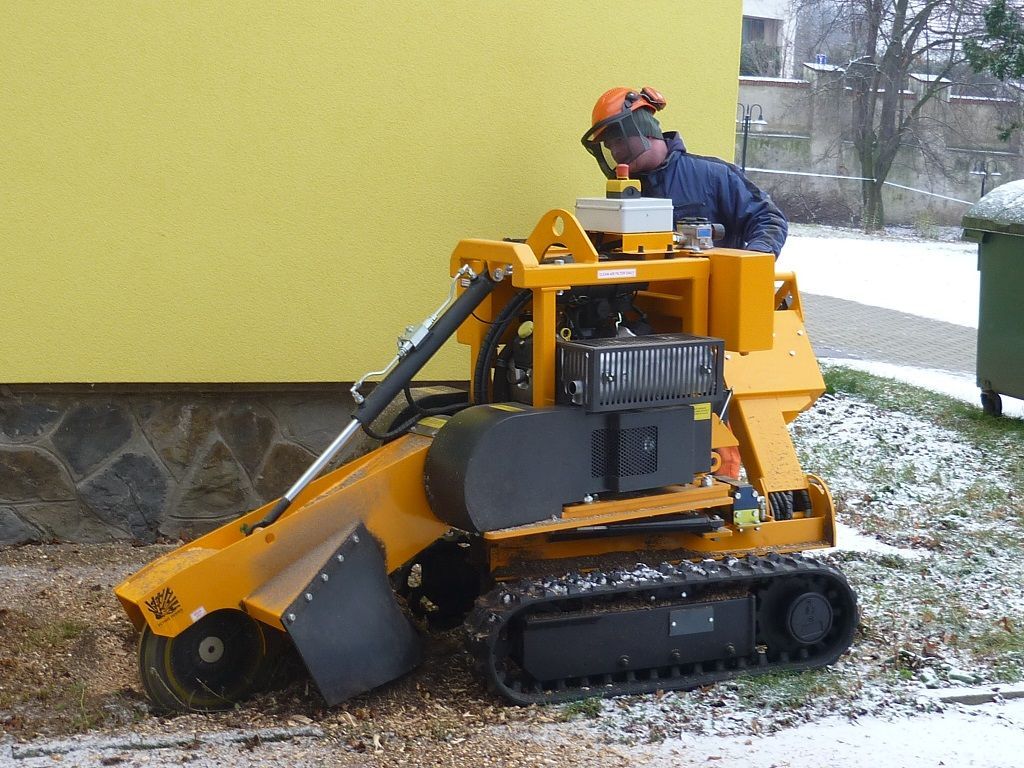 Ein Mann mit Helm bedient eine Maschine, auf der TG steht