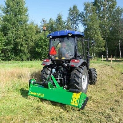 Ein roter Traktor steht am Rand einer unbefestigten Straße im Wald.