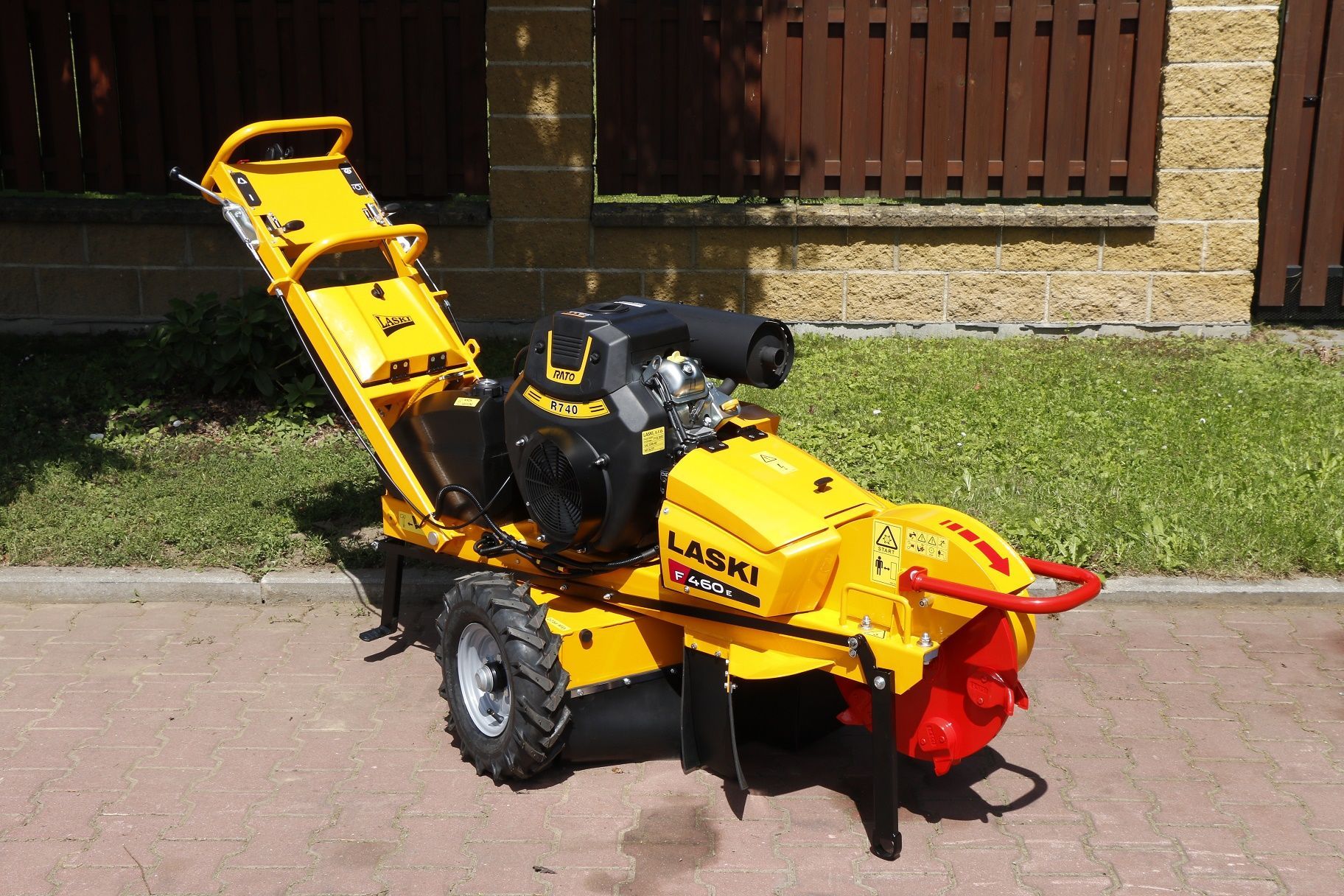 Eine gelbe Laski Stubbenfräse steht am Straßenrand