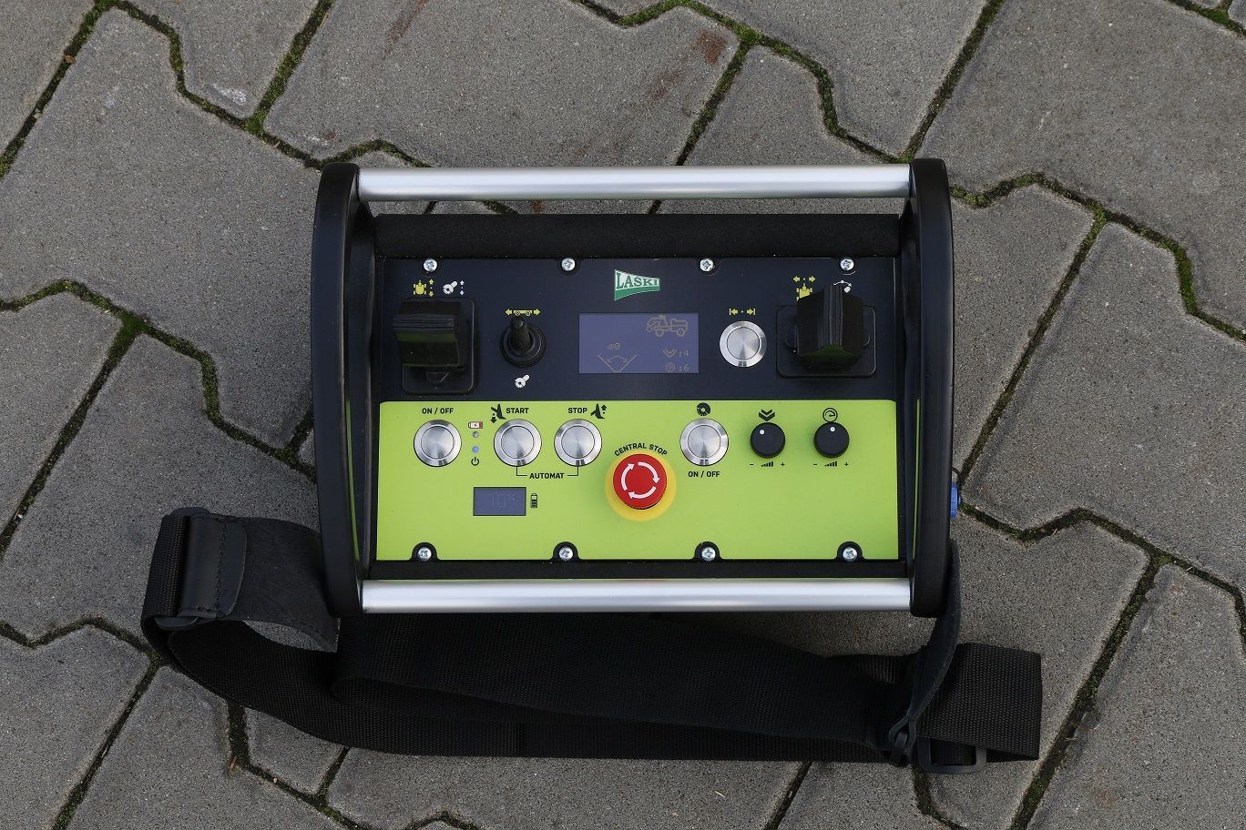 Ein schwarz-grünes Gerät mit einem roten Knopf auf der Oberseite