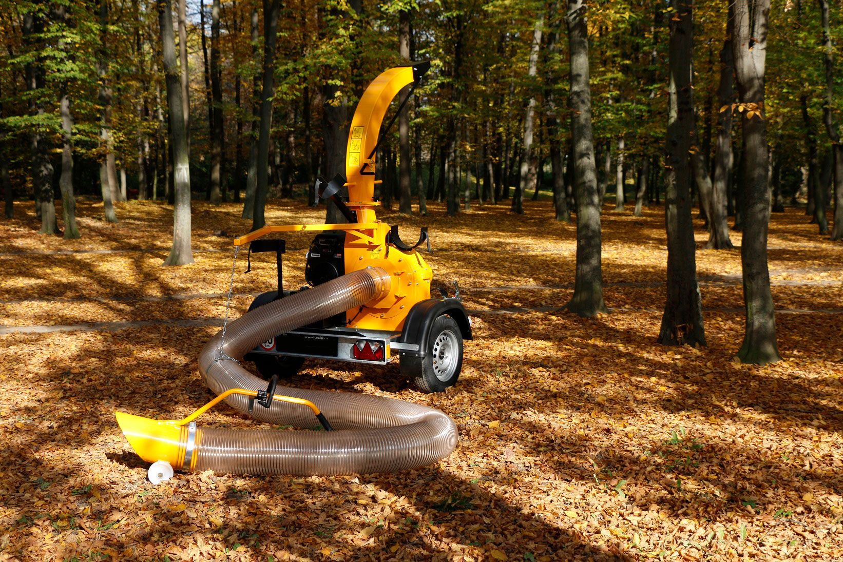 Ein gelber Laubsauger steht mitten im Wald.