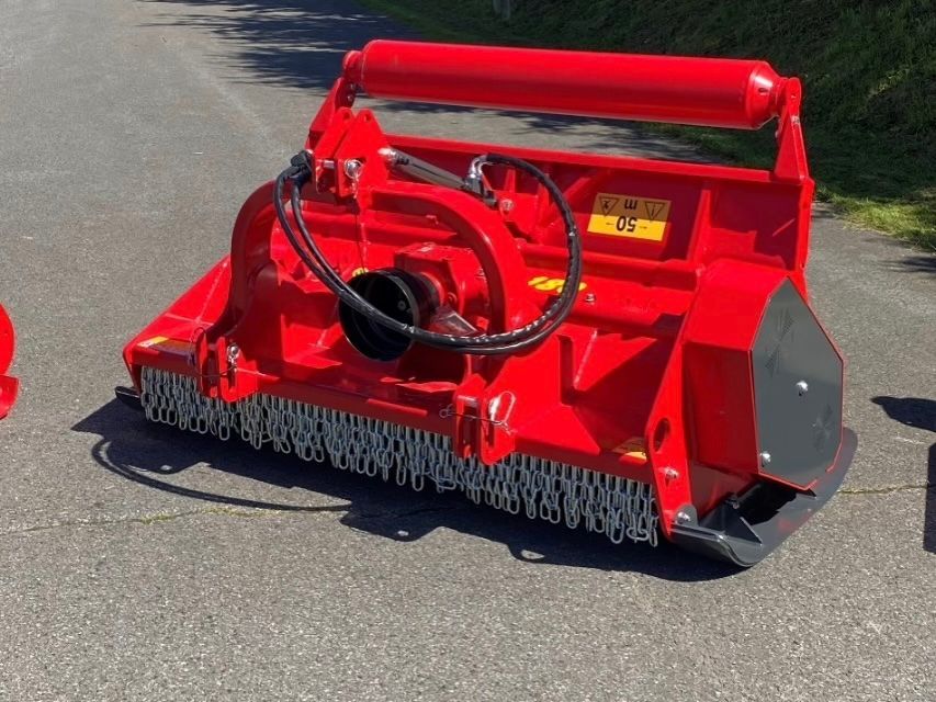Ein roter Traktor steht am Straßenrand