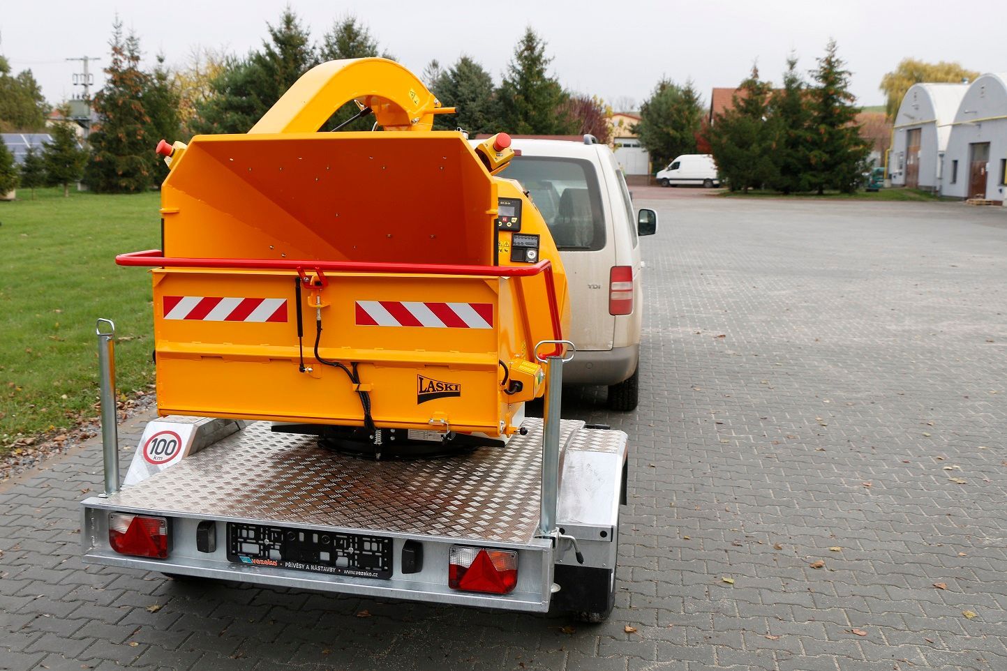 Eine gelbe Maschine ist an der Rückseite eines Anhängers befestigt