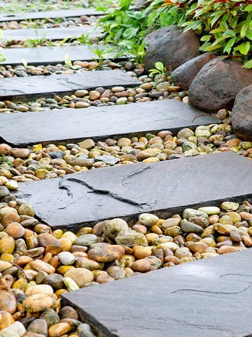 A stone walkway surrounded by rocks and plants in a garden.