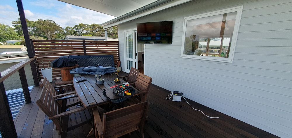 Outdoor Patio With Wooden Deck and Furniture — AitkenTech in Batemans Bay, NSW