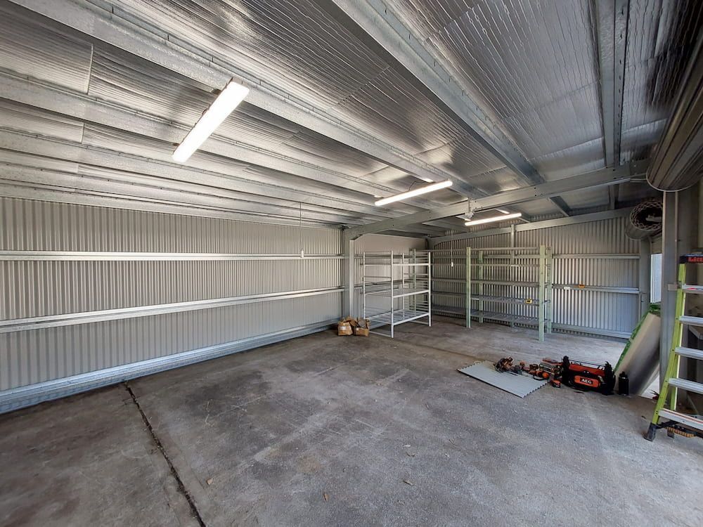 Large Empty Garage With Shelves and Ladder — AitkenTech in Batemans Bay, NSW