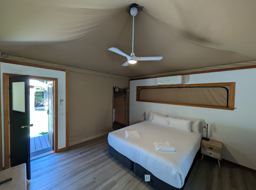 Modern Glamping-Style Bedroom With a Large Bed, Wooden Accents, Ceiling Fan — AitkenTech in Bermagui, NSW
