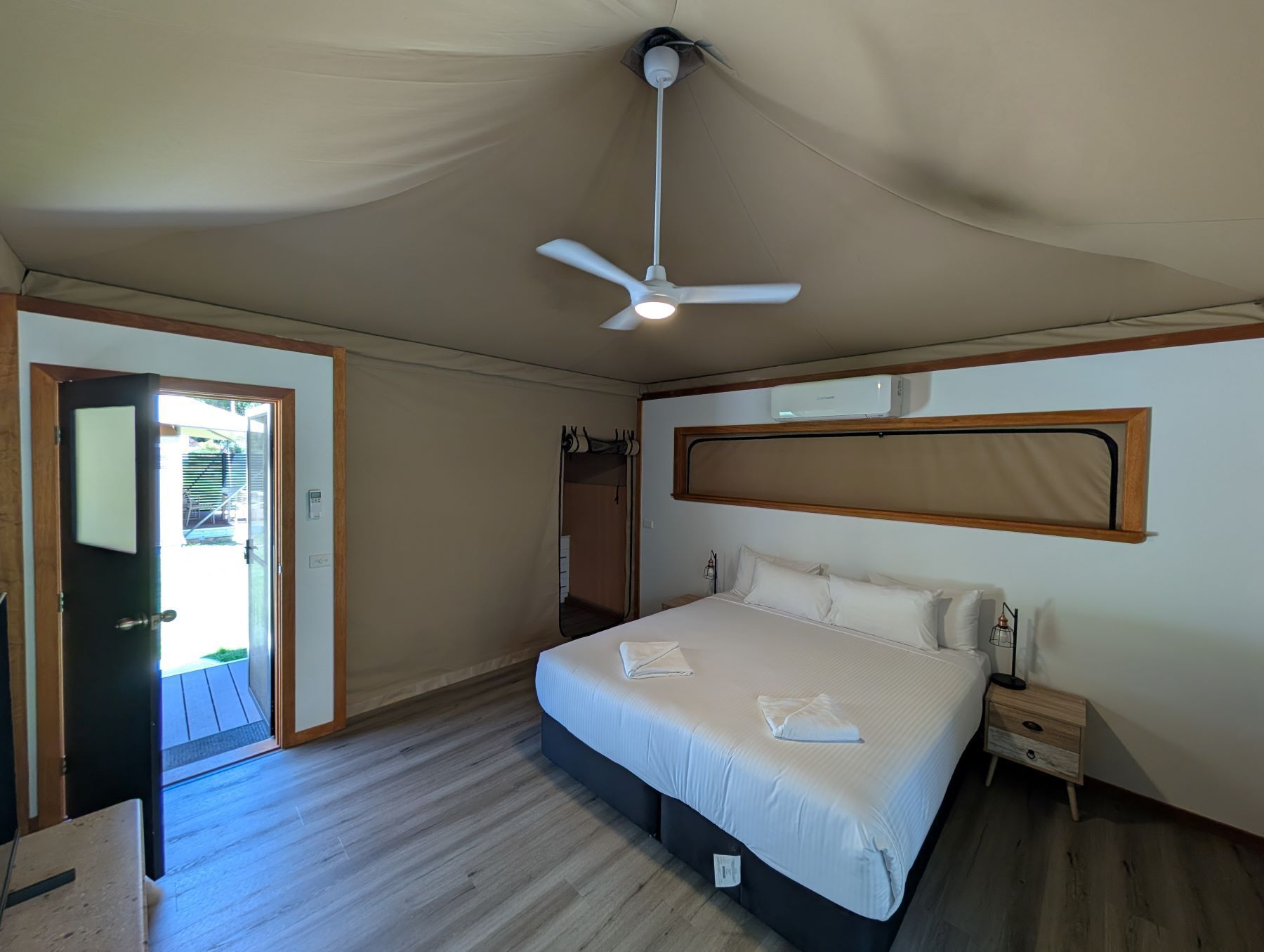 A Bedroom With a Large Bed and a Ceiling Fan — AitkenTech in Narooma, NSW