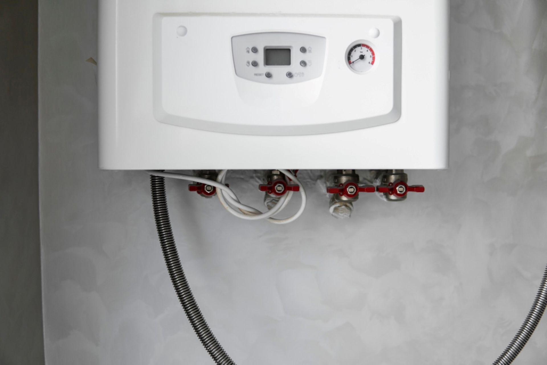 A White Boiler is Hanging on a Wall With a Hose Attached to It — AitkenTech in Bermagui, NSW
