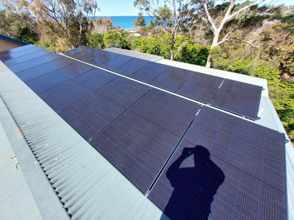 A Shadow of a Person is Cast on a Roof With Solar Panels — AitkenTech in Narooma, NSW