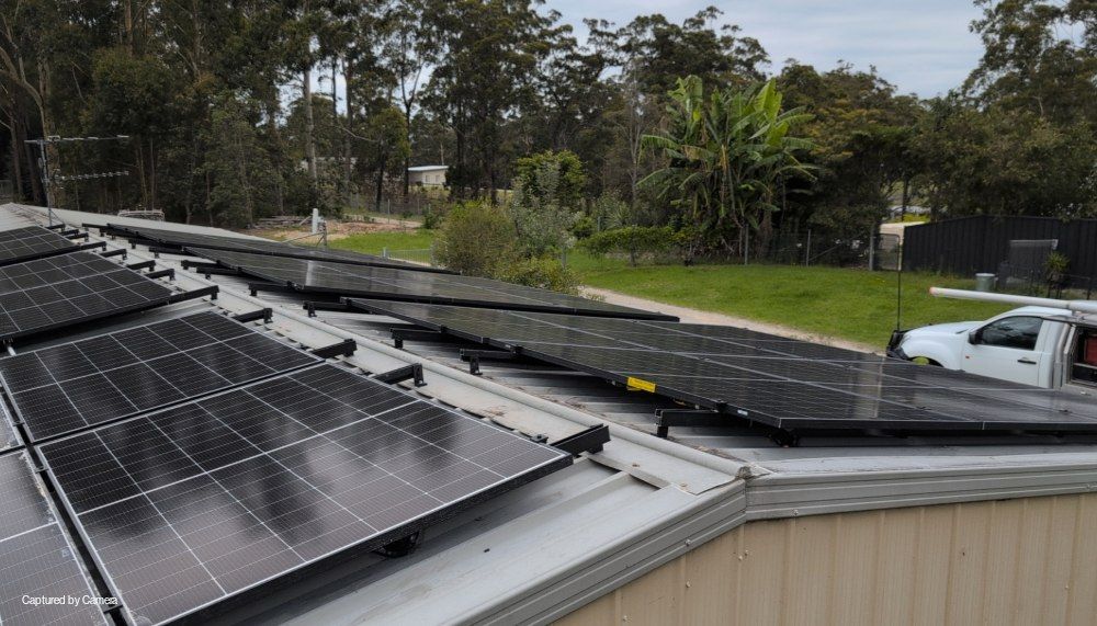A White Truck is Parked on the Roof of a Building With Solar Panels — AitkenTech in Narooma, NSW
