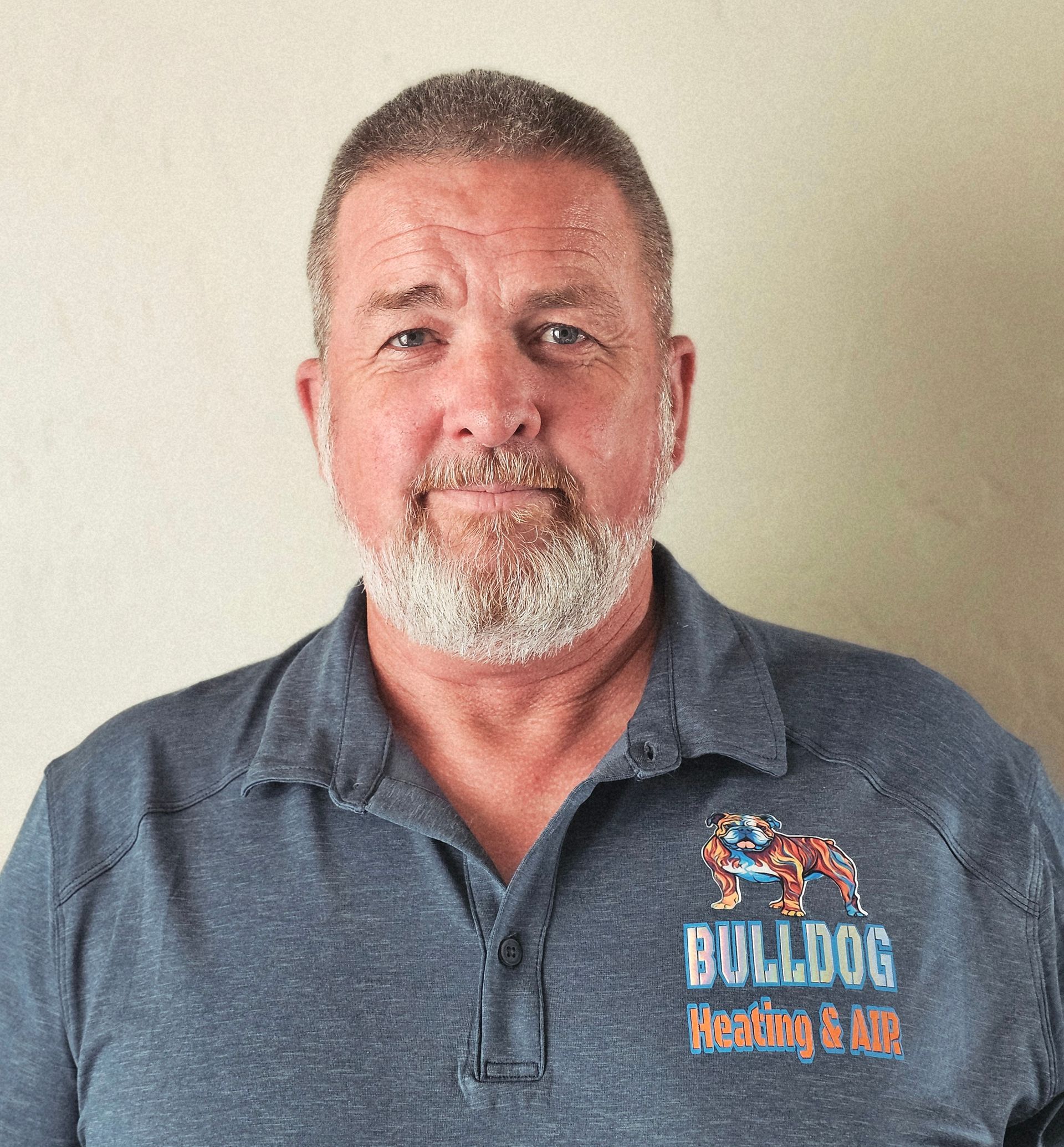 Matt, the owner of Bulldog Heating and Air, wearing a blue polo shirt with 